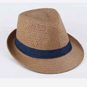 Detailed view of straw fedora hat with navy blue denim ribbon band on white background