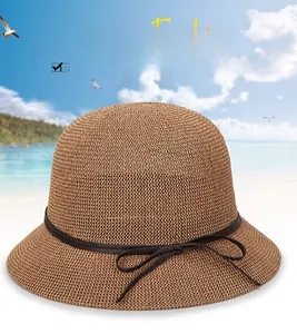 Detail of a brown woven sun hat featuring a delicate bow and tight breathable texture