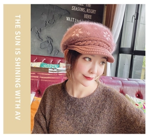 Detail of pink knitted beanie with white snowflake embroidery and cable knit texture