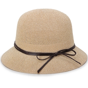 Detail of knitted beige straw sun hat featuring a dome shape and brown ribbon bow tie