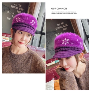 Detail of purple knitted winter hat featuring snowflake patterns and plush texture