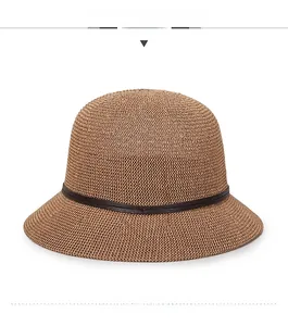 Detail of dark brown knitted cloche hat with thin faux leather strap and round top