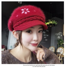 Detail of red plush knit beanie with snowflake pattern and stylish short brim