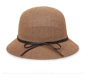 Side view of brown knitted sun hat with a dark brown ribbon bow detail on white background