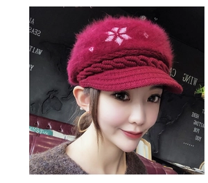 Detail of dark red knit beanie with soft faux rabbit fur texture and white snowflake pattern