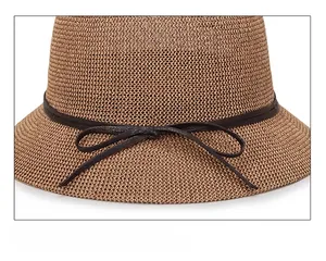 Close-up of tan knitted sun hat featuring a delicate dark brown faux leather bow tie