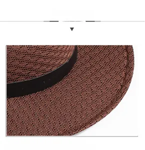 Detail of dark brown sun hat showing woven texture and black decorative band
