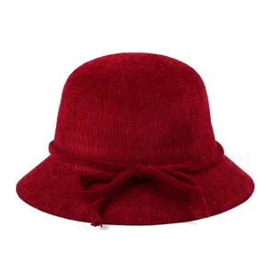 Détail d'un chapeau cloche tricoté bordeaux avec un nœud doux et texture chenille