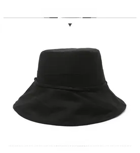 Close-up of a minimalist black wide-brim sun hat with a flat top and breathable cotton fabric