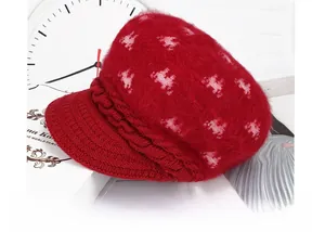 Detail of red knit beret with mohair texture and pink horse pattern embroidery