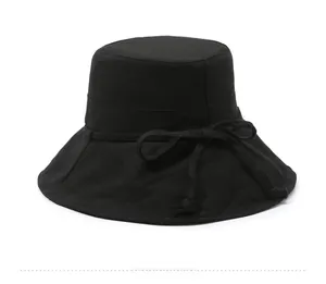 Close-up of black cotton canvas sun hat featuring a decorative ribbon bow and fine stitching