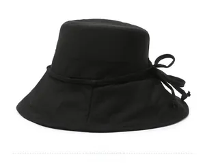 Detail view of the black cotton sun hat featuring a side bow drawstring decoration