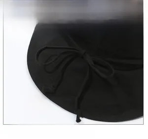 Detail of black cotton sun hat featuring decorative bow drawstring and twill fabric texture