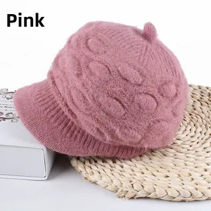Close-up of thick dusty pink knit hat featuring textured oval diamond pattern and short brim