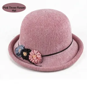 Detail of pink knitted hat with three 3D floral accents and woven texture
