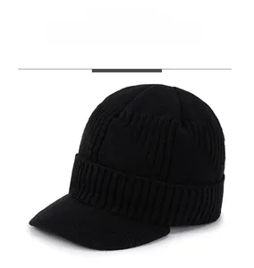 Detail of black knit beanie with visor showing sport embroidery and ribbed texture