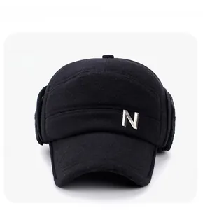 Detailed close-up of winter wool baseball cap with earflaps and metal letter emblem