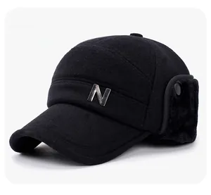 Detailed view of winter flap hat with faux fur lining and metal letter decoration