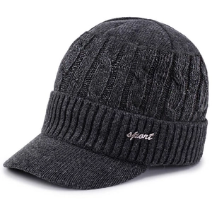 Detail view of deep gray cable knit winter hat with peak and sport badge accents