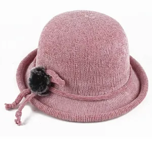 Detailed texture of pink knit basin hat featuring a fluffy pompom and lace-up accent