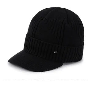 Detail of black knitted beanie with visor featuring a silver sport logo on the side