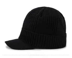 Detail view of black ribbed knit winter beanie with visor and metallic sport tag
