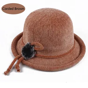 Detail of brown corduroy bucket hat with braided rope and faux fur pompom decoration