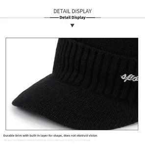 Detailed view of black knitted winter hat with a metal sport logo and sturdy peak