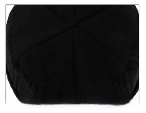 Macro view showing the six-petal top stitching detail of this black knitted beanie cap