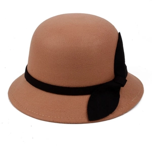 Detail view of khaki wool cloche hat featuring a black ribbon bow and neat edge stitching