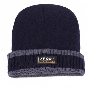 Détail d'un bonnet en maille bleu marine avec rayures grises et écusson Sport Fashion