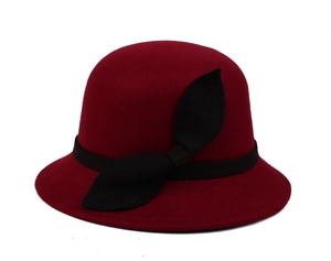 Macro shot of dark red cloche hat with black ribbon bow and textured wool felt fabric