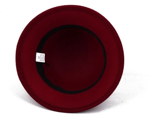 Close-up of wine red wool hat interior with black sweatband and size label details