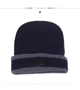 Détail du bonnet en maille bleu marine avec écusson sport et revers à rayures grises