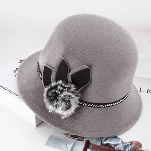 Close-up of elegant grey faux fur cloche hat with stylish pompon and woven ribbon detail