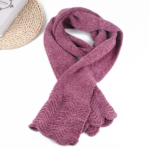 Detailed close-up of dark magenta knitted scarf with wavy edge and warm chenille texture