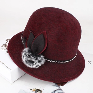 Detail of burgundy faux mink fur hat with leaf applique and decorative silver chain