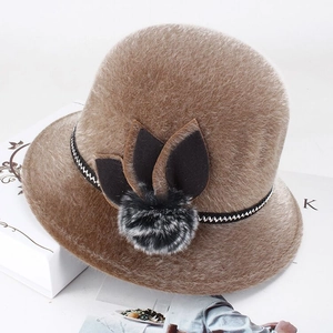 Detail of khaki faux fur bucket hat with pom-pom and leaf applique decoration