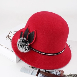 Detail of red faux mink wool hat with knit band and decorative fur pompom