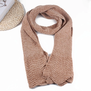 Detail of light brown knitted scarf with soft wavy edge texture and elegant pattern