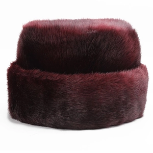 Détail d'un bonnet en fausse fourrure bordeaux avec une texture épaisse et brillante