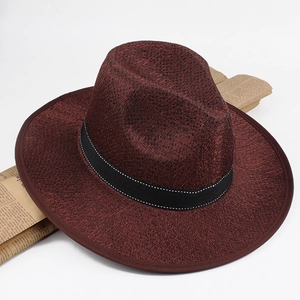 Detail of dark burgundy wide brim fedora hat with black ribbon and woven texture