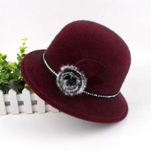 Detail of burgundy faux mink felt hat with decorative pompom and sequin band