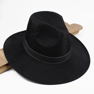 Detail of black straw fedora hat featuring a white-stitched ribbon and woven texture