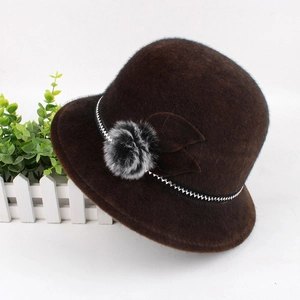 Detail of dark brown faux fur winter cloche hat with pompom and leaf decoration