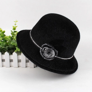 Detailed close-up of winter faux fur cloche hat with flower pom-pom and silver trim