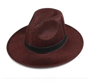 Detail of burgundy fedora hat showing textured weave and black band with contrast stitching