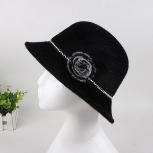 Macro detail of black faux fur winter hat with textured floral and silver stud accents