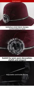Detail view of burgundy faux mink winter hat featuring rabbit fur ball and adjustable inner strap