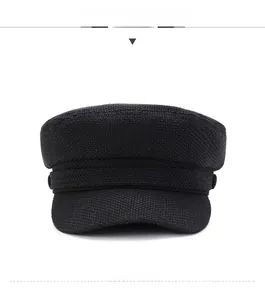 Détail de la casquette militaire en maille noire montrant la texture et le bouton latéral